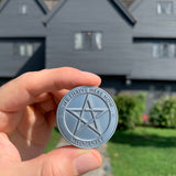 pentagram coin in front of Witch House